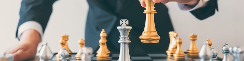man moves chess pieces metaphor
